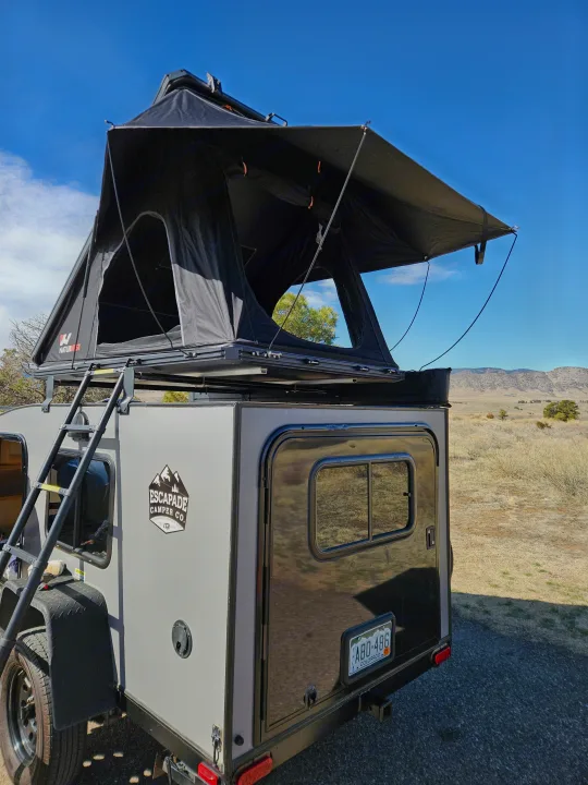 Compact RV rental: A grey Escapade Camper with a black NatureNest rooftop tent deployed in a scenic Colorado landscape.. Escapade Ridge 2018