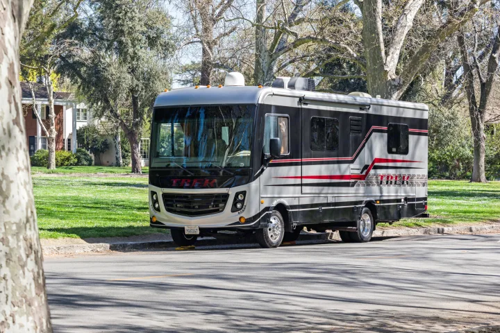 This grey and black Trek motorhome RV rental is parked on a sunny street, ready for adventure.. Monaco Trek 26HMD 2016