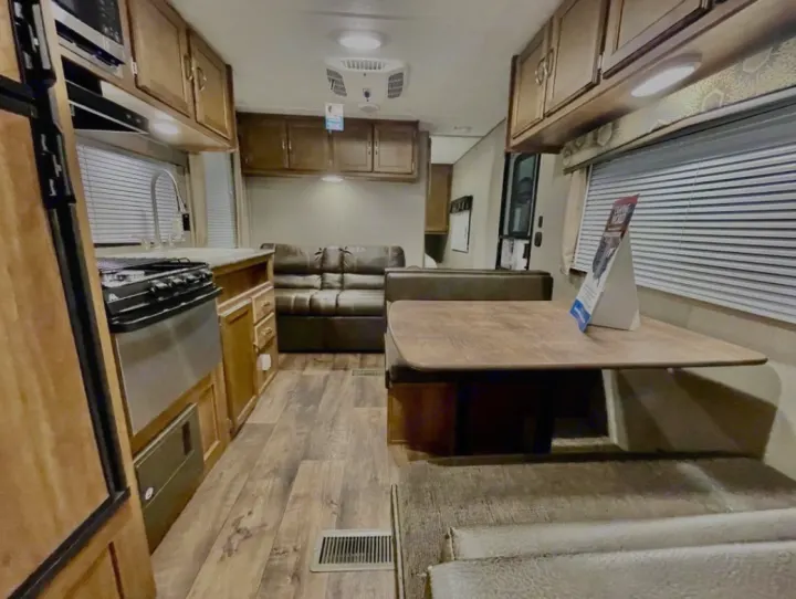 Spacious rv rental interior featuring a full kitchen, dining booth, and comfortable living area. Ideal for travel.. Keystone RV Summerland 2017