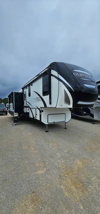 A striking white and black Durango fifth-wheel RV, parked on a gravel lot, ideal for your next RV rental trip.. K-Z Manufacturing Durango 2021