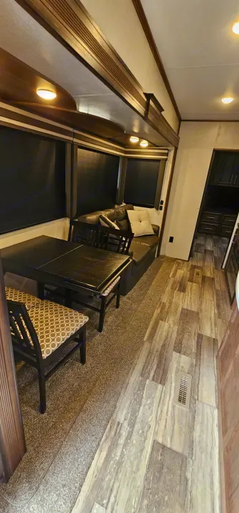 Experience comfort in this RV rental's spacious interior, featuring a dining area, sofa, and wood accents.. K-Z Manufacturing Durango 2021
