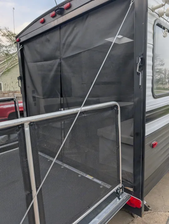 Toy hauler RV rental: Rear ramp door lowered, creating an outdoor patio deck with a mesh screen room and interior view.. Forest River 2700TH 2021