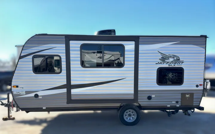 This Jayco travel trailer is ideal for an RV rental. A side view shows the striped camper with slide-out.. Jayco Jay Flight SLX7 184BS 2021