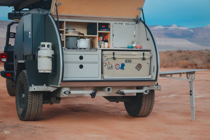 This compact RV rental trailer's open rear kitchen has a stove, sink, and Yeti cooler, ready for desert adventures.. Escapod Escapod Trailer 2022