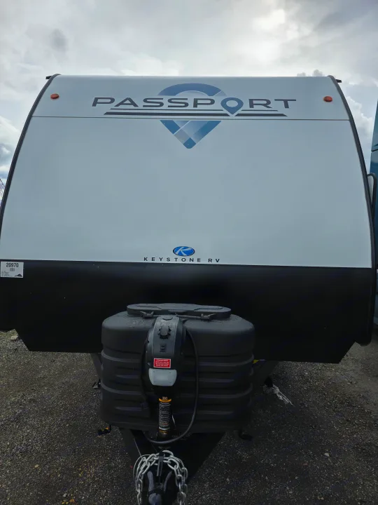 Front view of a white Keystone Passport travel trailer, a perfect RV rental for your next adventure.. Keystone RV Passport SL Ultra Lite 2024