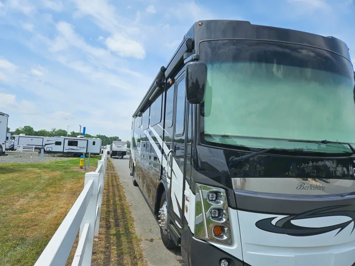 Black and white Berkshire RV rental parked at a lot with other RVs under a blue sky, ideal for travel.. Berkshire XL 2022