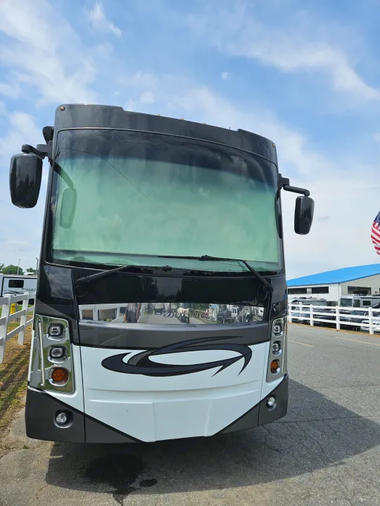 Front view of a large white and black Forest River Berkshire RV, perfect for rv rental, with a cracked windshield.. Berkshire XL 2022