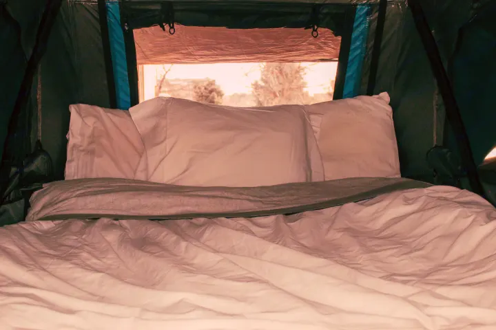 Cozy RV rental interior with a comfortable bed, perfect for camping trips and outdoor adventures.. Overlander HMDE 2025