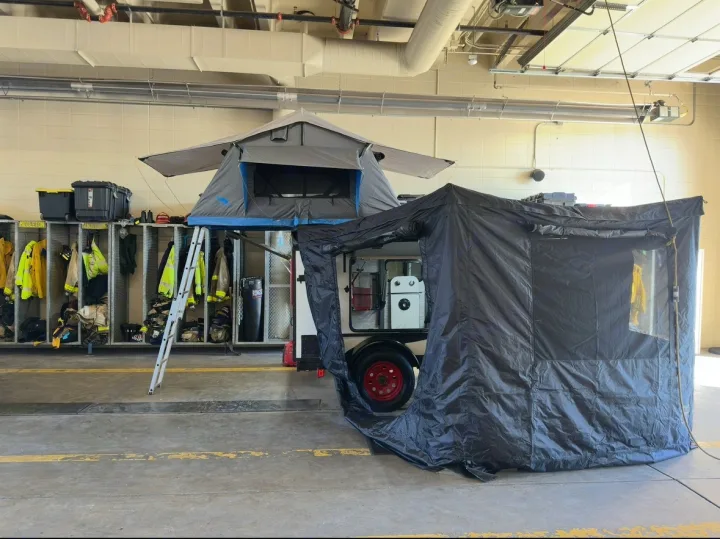 This mobile RV rental features an overland trailer with a deployed roof-top tent and a large side privacy room, ready for adventure.. Overlander HMDE 2025