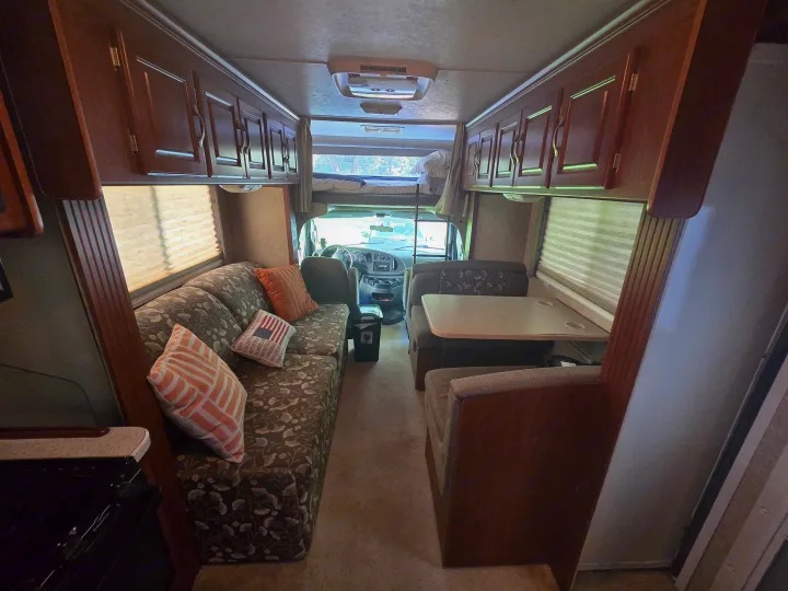 Cozy RV rental interior featuring a sofa, dinette, kitchen, and overhead bunk bed.. Four Winds Chateau Sport 2006