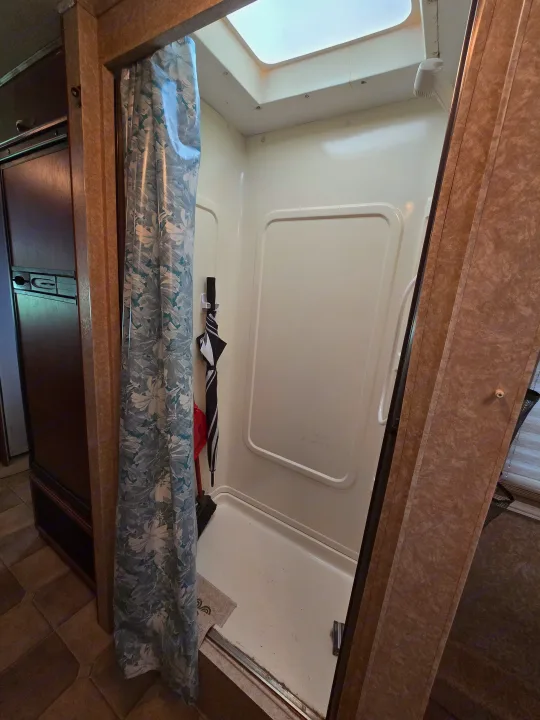 Compact RV rental interior featuring a functional shower with a skylight and clever storage.. Four Winds Chateau Sport 2006