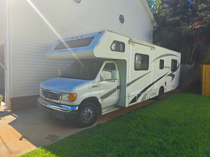 White Chateau Sport Class C motorhome parked on a driveway. Ready for your next RV rental adventure.. Four Winds Chateau Sport 2006