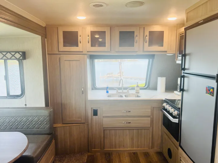 RV rental interior with kitchen, dining booth, and lake view.. Coachmen Freedom Express 2020