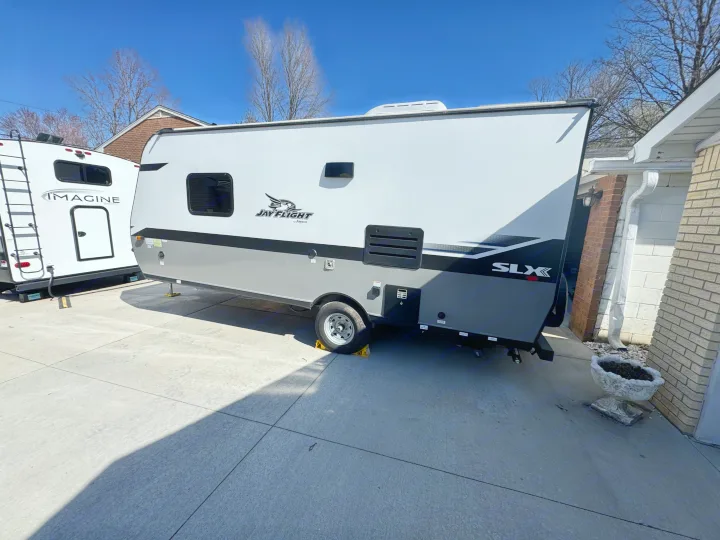White & gray Jay Flight travel trailer on a concrete pad. Perfect RV rental for your next outdoor adventure!. Jayco Jay Flight SLX 2022