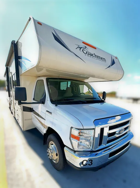 This white Coachmen Freelander Class C RV rental, a Ford motorhome, is shown parked on a bright day.. Coachmen Freelander 2020