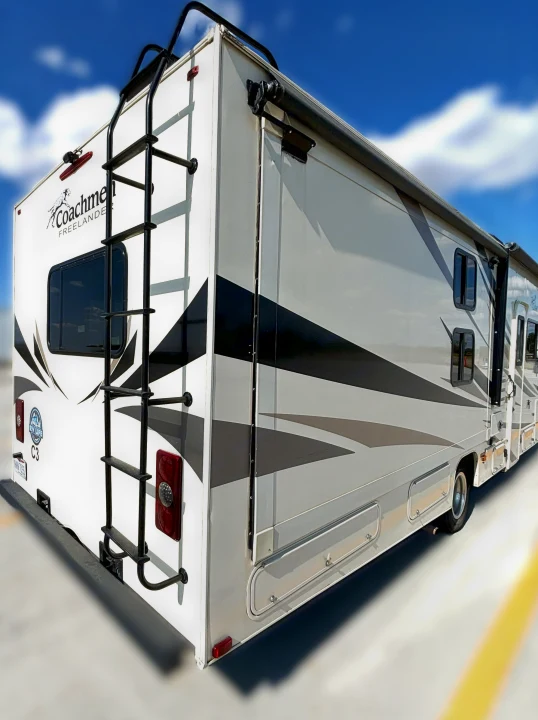 Explore the open road! This spacious RV rental features a ladder, awning, and ample storage, ready for your next adventure.. Coachmen Freelander 2020