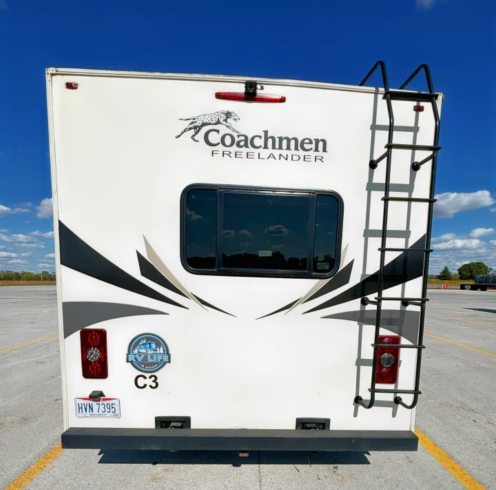 Rear view of a white Coachmen Freelander RV, showing a ladder, reflective window, and Ohio plate. Ideal for an RV rental trip.. Coachmen Freelander 2020