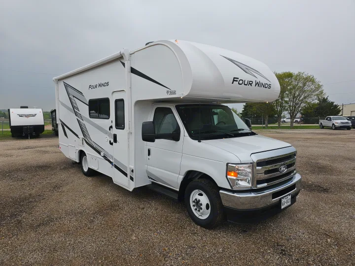 White Four Winds Class C RV rental on a gravel lot, ready for your next adventure.. Thor Motor Coach Four Winds 2026