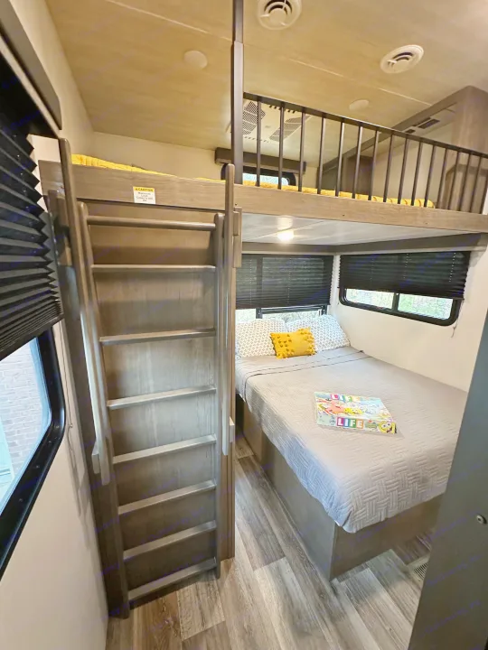 RV rental with modern interior: cozy lower bed, upper bunk with ladder, ideal for family trips.. Keystone RV Cougar 2021