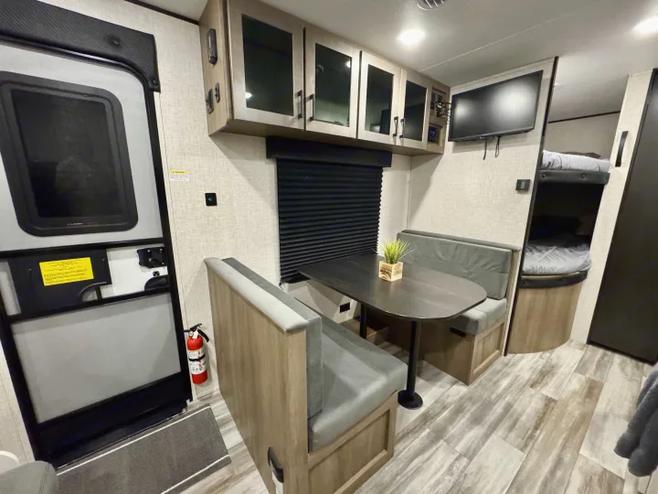 Cozy RV rental interior with a dinette, TV, bunk beds, and storage for a comfortable travel experience.. Jayco 260BH 2025