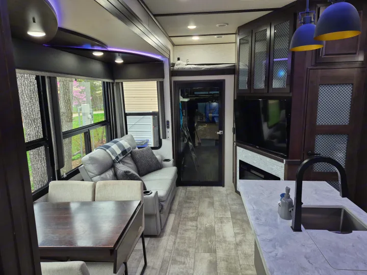 Spacious, modern RV rental interior with living area, kitchen, and dining for comfortable travel adventures.. Grand Design Momentum 2022