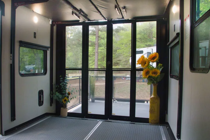 Experience this RV rental's versatile toy hauler space. Large doors reveal a patio deck & serene outdoor campsite.. Alliance Valor 2022