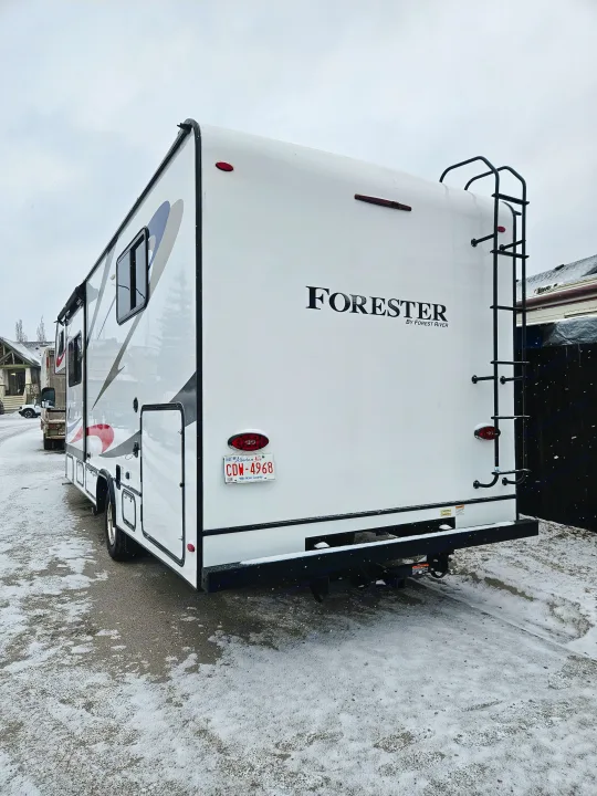 RV rental: A white Forester motorhome parked outdoors on a snowy day. Rear view showing ladder & license plate.. Forester 2651 CDW 2022