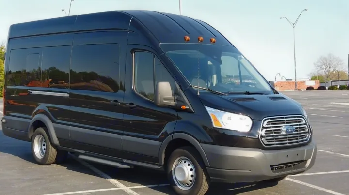 Spacious black Ford Transit high-roof van, perfect for group or rv rental travel. Parked in a lot.. Ford Custom Transit 2017
