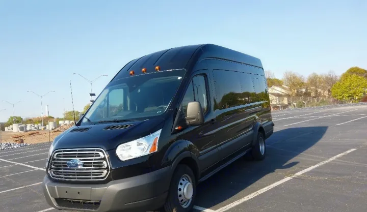 A black high-roof Ford Transit van, ideal for RV rental conversions, is parked facing forward in a large outdoor lot.. Ford Custom Transit 2017