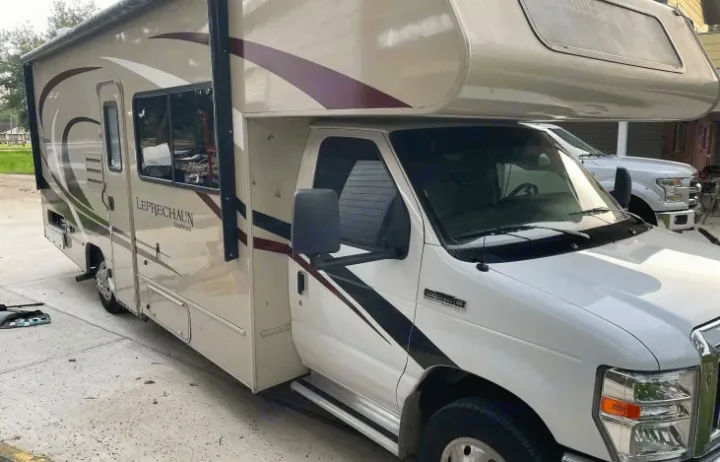White and tan Leprechaun Class C RV rental, a Ford E350 motorhome, parked on concrete.. Coachmen Leprechaun 260RS 2020