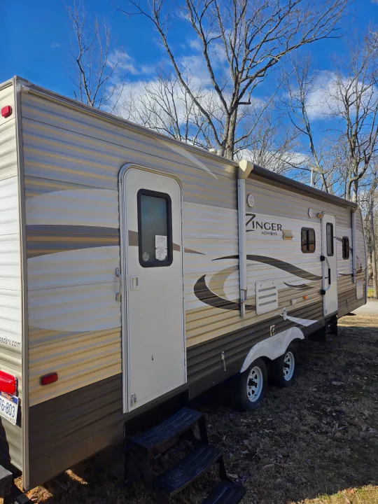 Spacious Zinger travel trailer RV rental parked outdoors under a blue sky, ready for your next adventure.. Crossroads RV Zinger 2014
