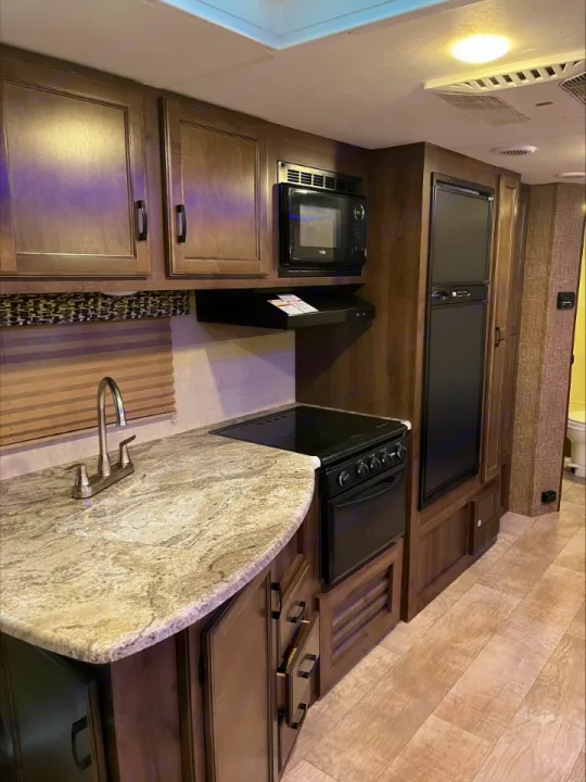 Explore this RV rental's functional kitchen, complete with a sink, microwave, stove/oven, and refrigerator, ready for your travels.. KZ Connect 2018