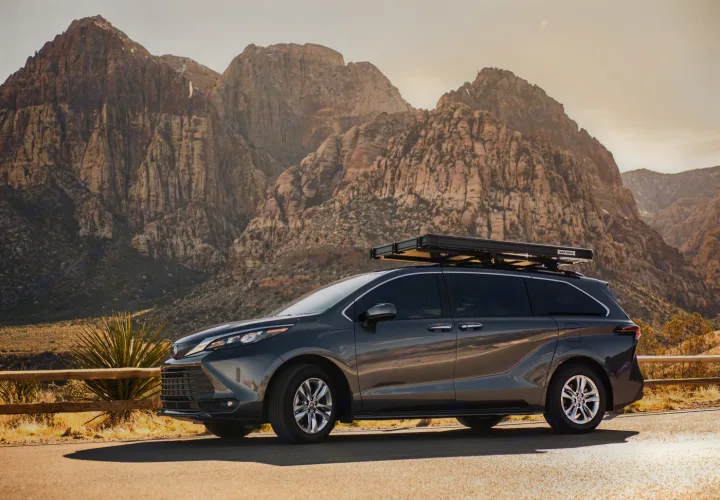 A dark gray Toyota Sienna minivan, fitted with a rooftop tent, for your unique RV rental adventure exploring rugged mountains.. Toyota Other 2025