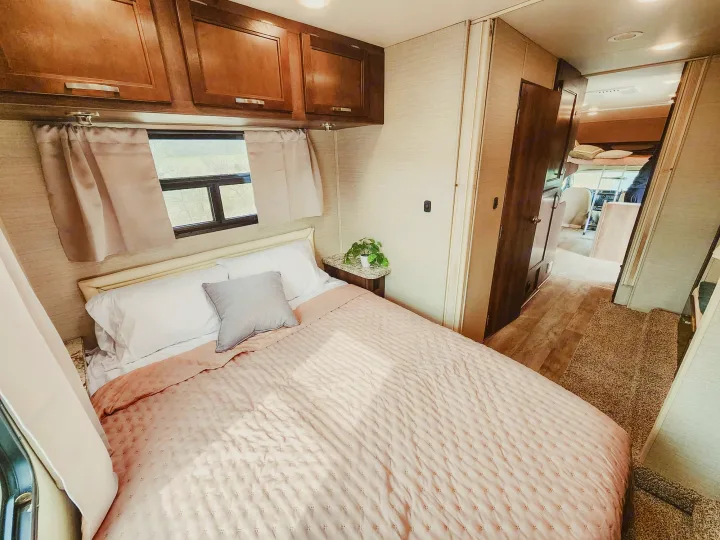 Relax in this comfortable RV rental bedroom, featuring a plush bed, ample storage, and a bright, inviting interior for your next road trip.. Jayco Redhawk 2019