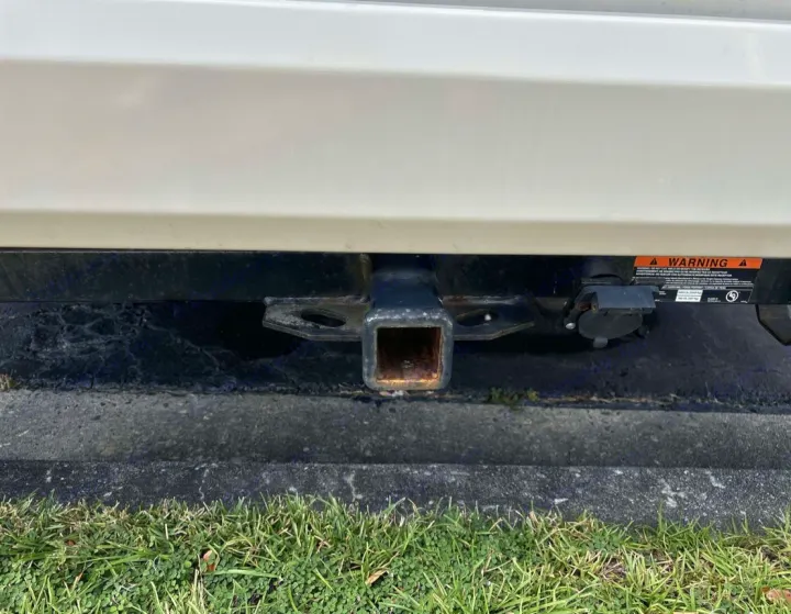 RV rental's rear: closeup of a trailer hitch receiver, a power connector, and a warning label. Ready for towing.. Thor Chateau Sprinter 2018