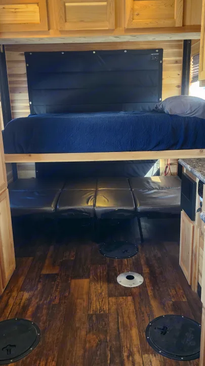 Versatile RV rental interior with bunk bed, sofa, and floor openings. Perfect for adventure, including ice fishing!. Ice Castle Fish Houses Toy Hauler 2022