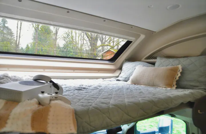 Cozy RV rental overhead bed with an Xbox & window view. Perfect for travel and relaxing in a camper van.. Jayco Greyhawk 31F Bunkhouse 2025