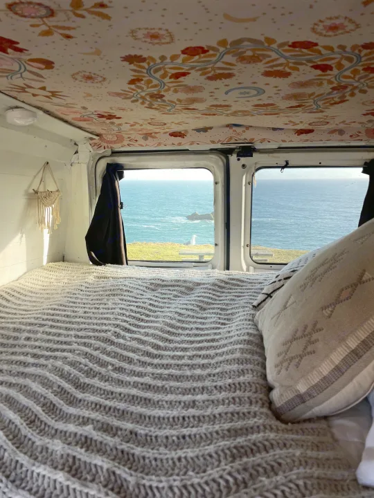 Cozy rv rental bed with scenic ocean view and a seagull outside. Perfect for coastal adventures!. Ford Econoline 150 2011