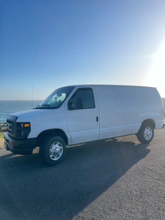 Explore the coast in this white van, an ideal rv rental for scenic road trips by the ocean.. Ford Econoline 150 2011