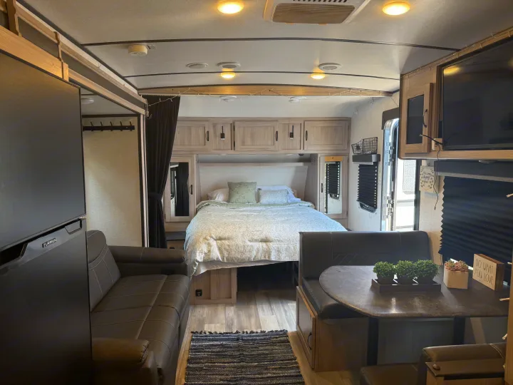 Bright RV rental interior featuring a cozy bedroom, spacious living area with sofa, and dining nook, perfect for travel.. Forest River Coachmen Northern Spirit Ultra Lite 2023