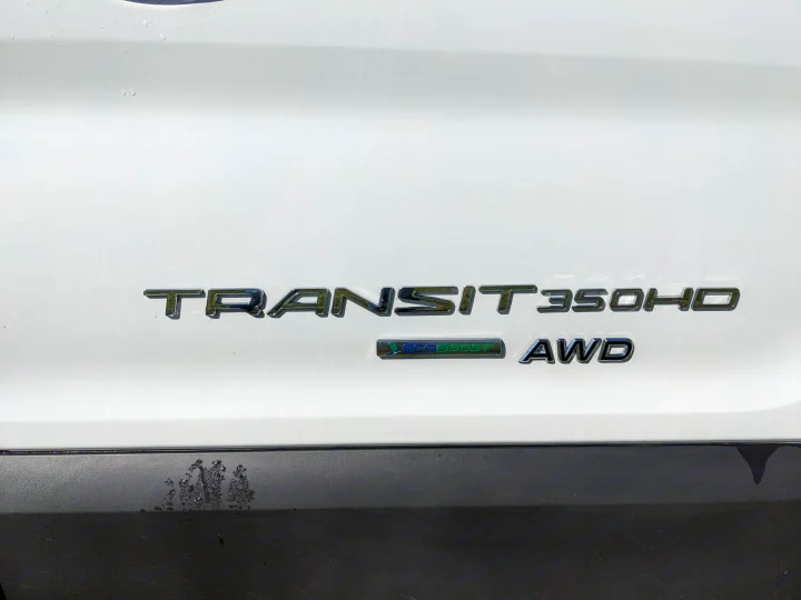 Rear badging of a white Ford Transit 350HD EcoBoost AWD van, ideal for rv rental or conversion.. East to West Alita 2025