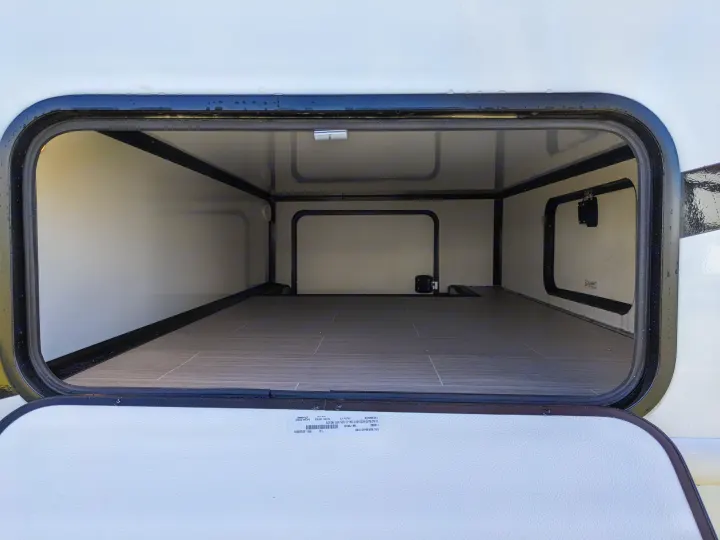 Empty, clean RV rental storage compartment, open and ready for your travel essentials and gear.. East to West Alita 2025