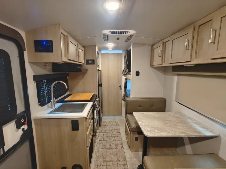 RV rental interior with a compact kitchen, dinette, and bunk beds. Ideal for your next road trip adventure.. Geopro 19Bh 2021