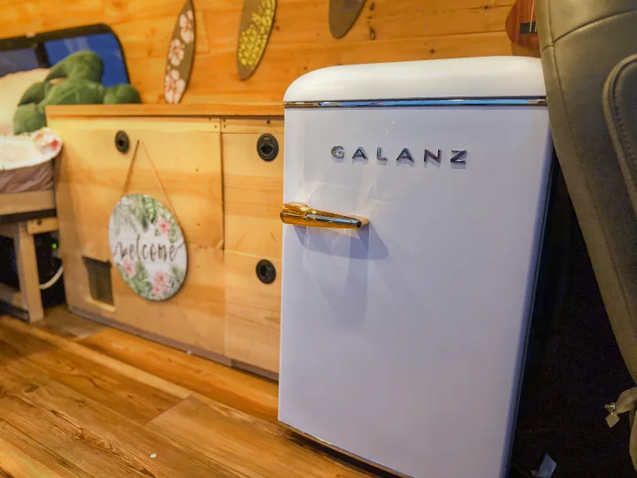 White Galanz retro fridge in a cozy RV rental. Wood interior & beachy decor for adventure.. Chevrolet Express 1999