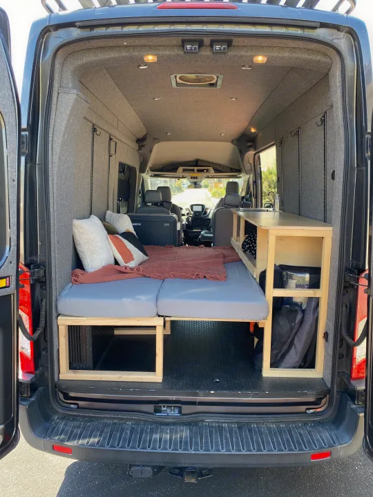 Spacious camper van interior, perfect for your next RV rental adventure. Features bed, kitchen, & ample storage.. Ford Transit 2016