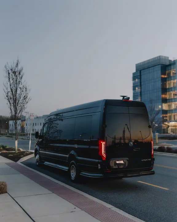 Black Mercedes-Benz Sprinter luxury van by Ultimate Toys, an Ohio RV rental, parked at dusk near modern buildings.. Ultimate Toys Ultimate Freedom XL 2025