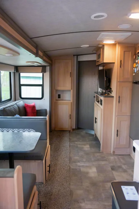 Spacious RV rental interior featuring a dinette, comfortable sofa, and well-equipped kitchen area with TV.. Cruiser RV Radiance Ultra Lite 2020