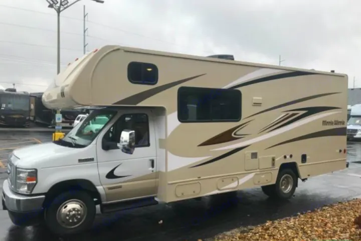 Side view of a beige Winnebago Minnie Winnie Class C RV, an excellent RV rental option for your next adventure.. Winnebago Minnie Winnie 2023