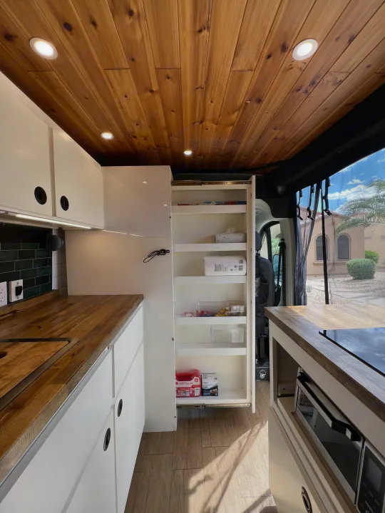 Inside this modern rv rental, a bright kitchen boasts wood ceilings, white cabinetry, integrated appliances, and a pull-out pantry.. Dodge Ram Promaster 2500 2022
