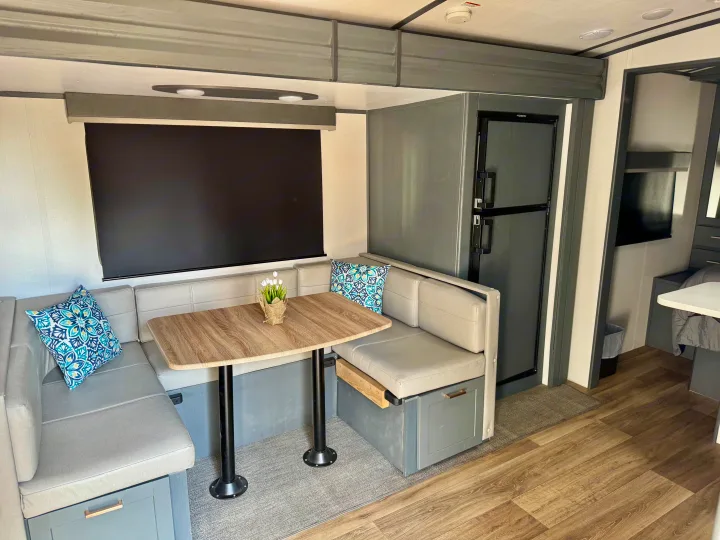 RV rental: Modern grey dinette, wood table, and compact kitchen with a Dometic fridge.. Keystone RV Bullet Premier Ultra Lite 2022